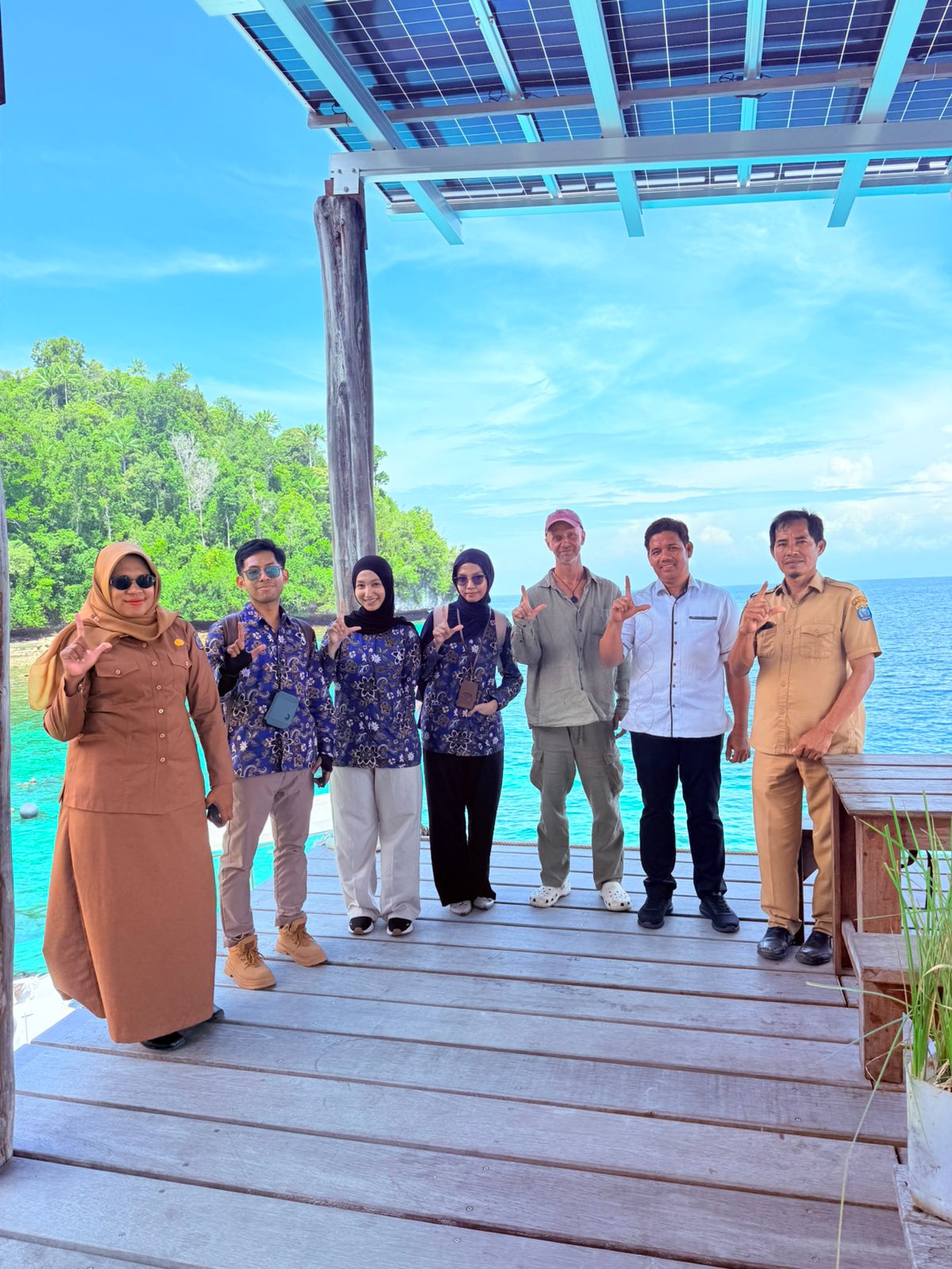 Government and community partners standing together at a Raja Ampat waterfront site visit